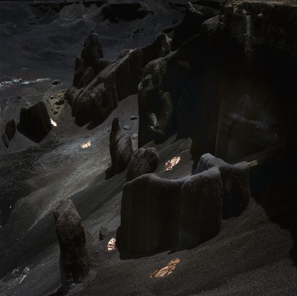 Copper scattered among dark sculpted volcanic rocks