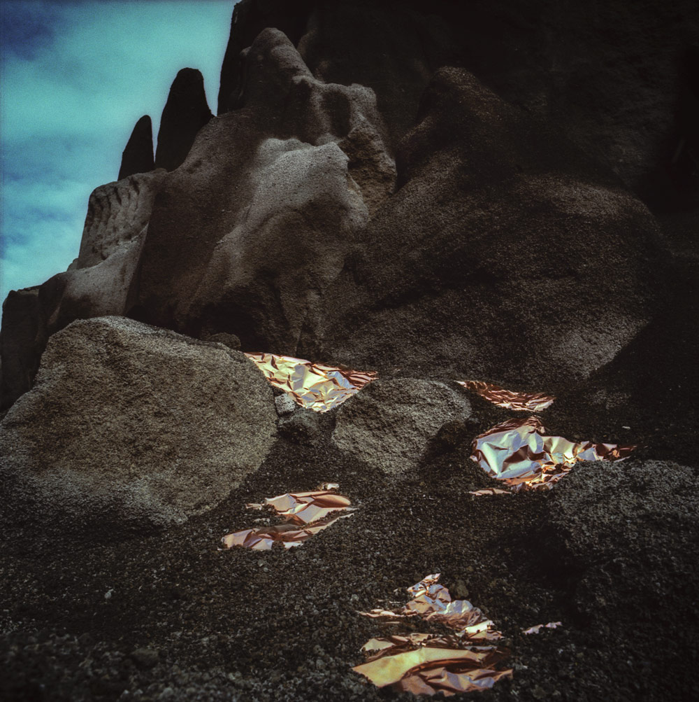 Reflective copper sheets on a volcanic slope beneath a blue sky