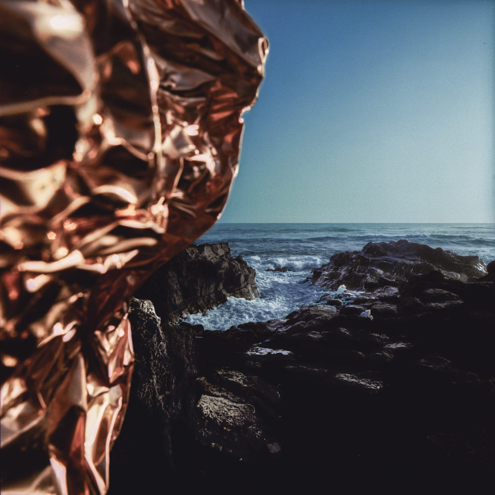 Close-up of copper against the rocky coastline and sea