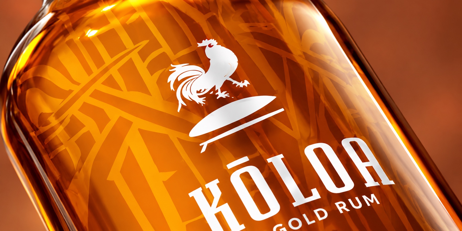 Angled detail of the gold rum bottle with sugarcane pattern and white rooster