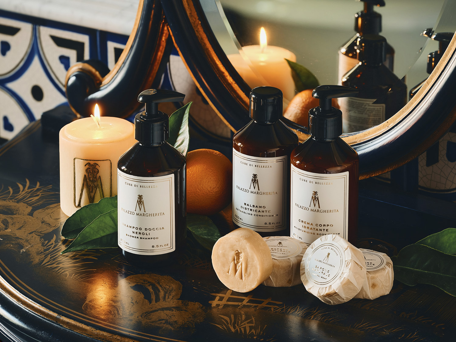 Palazzo Margherita beauty care bottles and natural soaps with citrus and candles on a painted tray