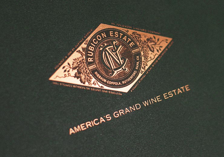 Copper Rubicon Estate emblem on deep green paper
