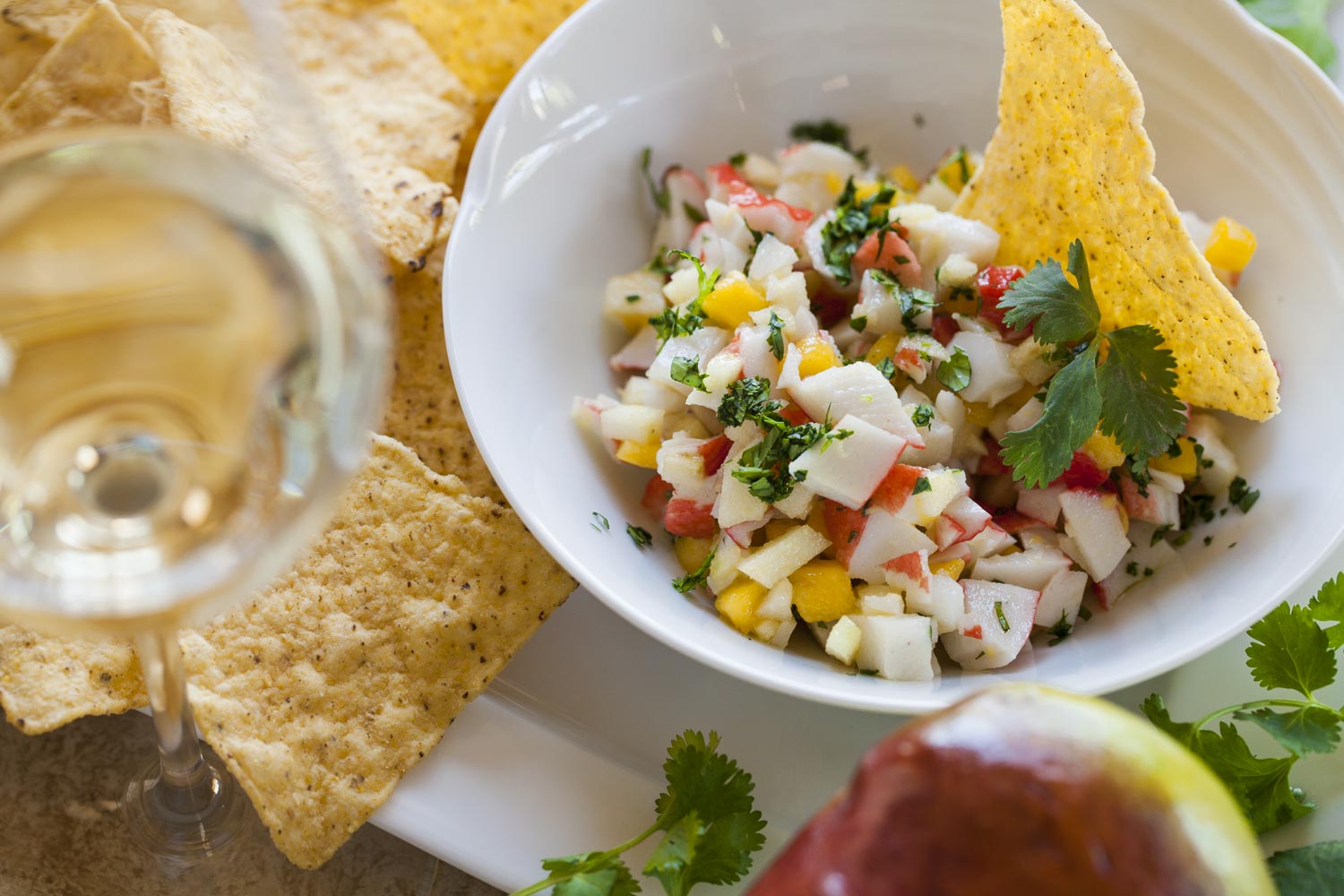 A colourful salad with tortilla chips, fresh herbs and white wine
